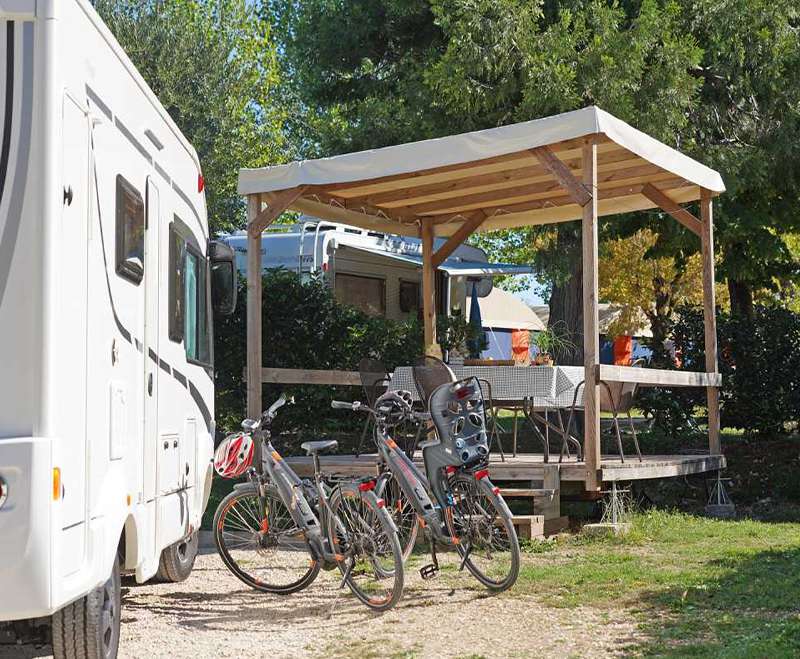 camping-mit-hund-fornella-gardasee-wohnmobil-stellplatz-wohnmobil-mit-raedern-vor-pavillon